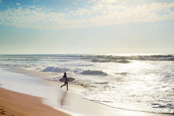 Fototapeta na wymiar Surfer running to surf