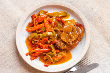 Healthy rustic dinner - pork chop with a side dish of stewed peppers