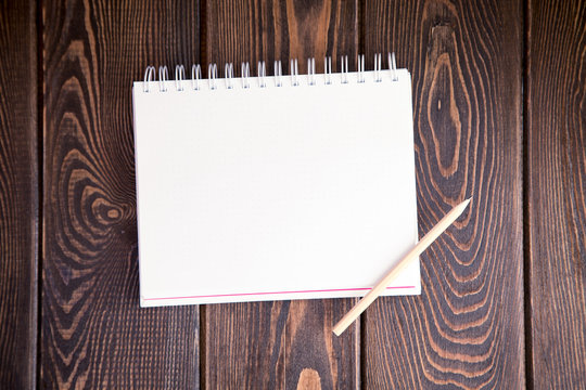 notebook on a wood background. Layout for inserting text and image