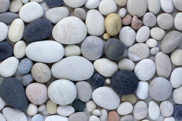 Group of white, grey and black pebbles, one by ony, simplicity stone background