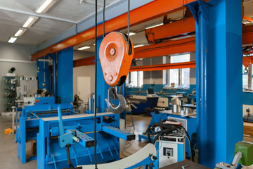 Crane hook. The system of pulleys and ropes, a hanging mechanism in the production area. Movement remote control pendant switch for overhead crane in the factory