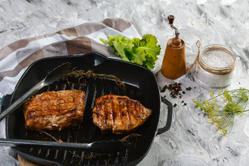 Grilled steak on on iron pan with spices and herbs . Top view with copy space