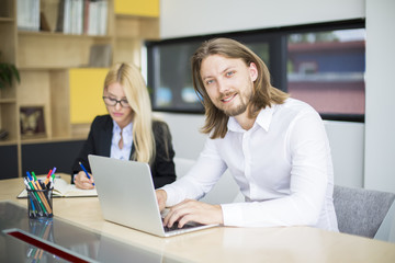 Two business people discussing new project in modern office