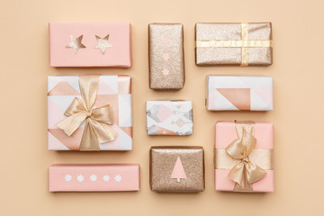 Gift wrapping composition. Beautiful nordic christmas gifts isolated on gold background. Pink and gold colored wrapped xmas boxes.