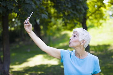 Senior woman taking selfie in the park after workaout