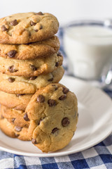 Stack of fresh homemade chocolate chip cookies and glass of milk