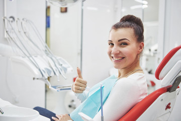 Satisfied patient showing her perfect smile after treatment in a dentist clinic
