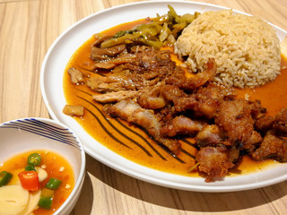 Stewed pork leg on rice (Kao Kha Moo) with boiled egg garlic and kale in bowl on table. food Popular menu Thailand.