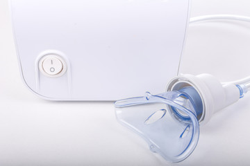 Portable asthma compressor nebulizer machine for children.Isolated on white,focus on mask
