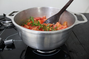 Aluminum pan with tomato sauce and basil bunches