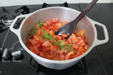 Aluminum pan with tomato sauce and basil bunches