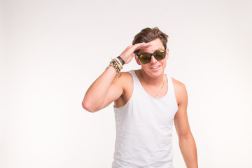 Handsome funny man in sunglasses over white background with copy space
