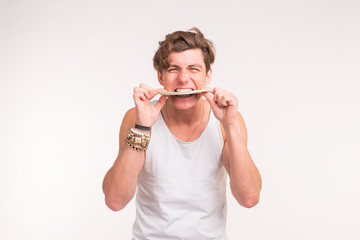Concept of financial wealth, prosperity and lottery winnings - Young handsome man bites bundle of...