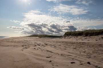Beach scene with dunes, clouds and sand.  Coast