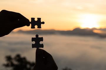 Silhouette Woman hands connecting couple puzzle piece against sunrise, Business solutions, target, success, goals and strategy concepts