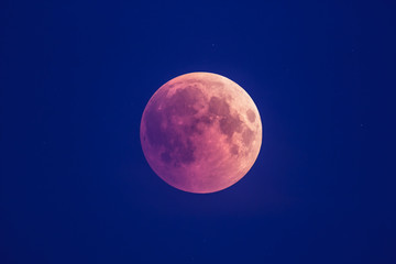 Super Bloody Moon, beginning of full eclipse phase against blue starry sky background