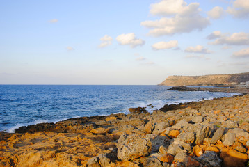 breaking waves at the red rocky coast of Sissi on Crete in Greece