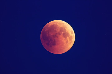 Super Bloody Moon, beginning of full eclipse phase against blue starry sky background
