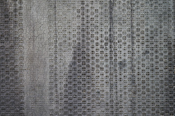 Old perforated metal with grey bituminous coating
