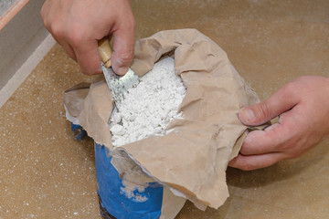 worker takes a spatula alabaster in a bag