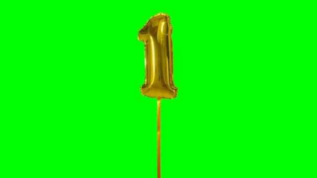 Number 1 one year birthday anniversary golden balloon floating on green screen