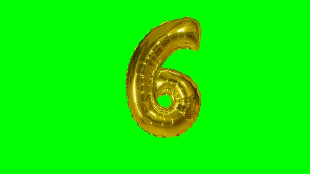 Number 6 six years birthday anniversary gold balloon floating on green screen