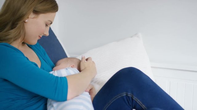 Young mother breastfeeding her baby as they doze off to sleep