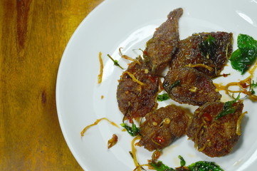 spicy stir fried crispy catfish curry with herb on plate