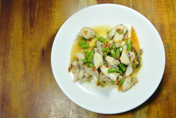 spicy stir fried squid with basil leaf on plate