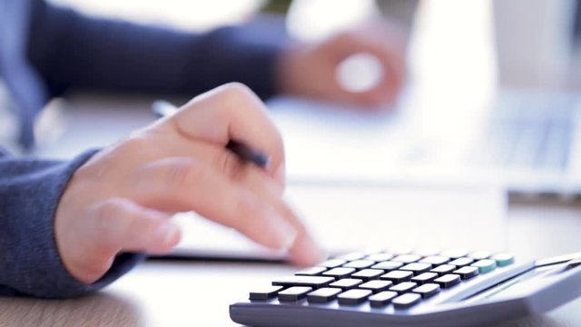 a woman making some calculations on a calculator