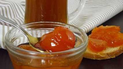 Bread and delicious jam of ripe apricots on the table.