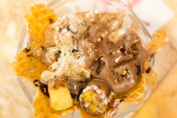 Top view image defocused ice cream and banana in glass cup on blurred table background,