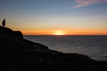 Man on Cliff Watching Sunset