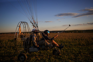 Cabin paratrike, takeoff of the glider. Paraglider acceleration on the field at sunset