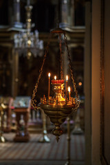 The interior of the Russian Orthodox Church. Candles in the Church, hand holding candle and lights