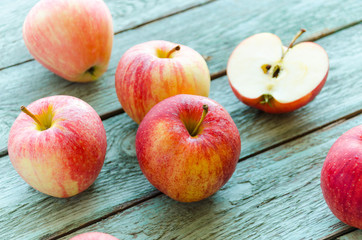Red apples on turquoise wooden background. Autumn days.