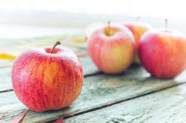 Red apples on turquoise wooden background. Autumn days.
