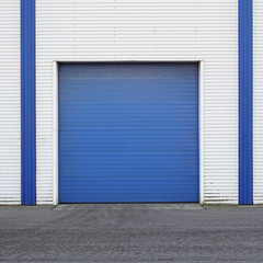 White Industrial warehouse with blue door for trucks