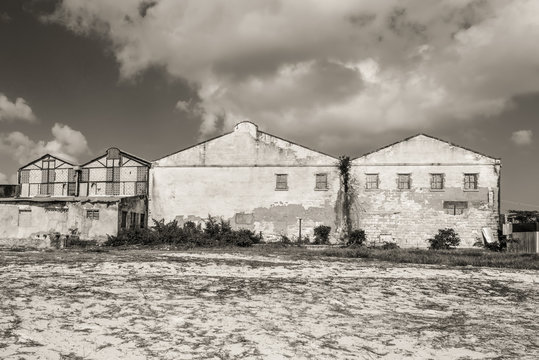 Abandoned old factory buildings on the shore. Sepia tinted. Symbol for economic depressions.