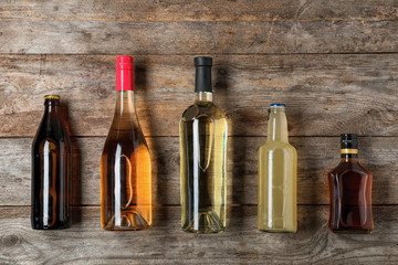 Bottles with different alcoholic drinks on wooden background, top view © New Africa