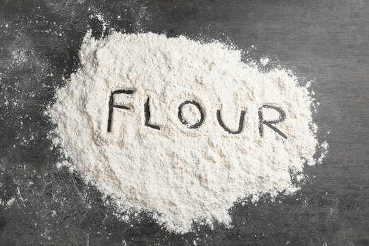 Word written on flour scattered over table, top view
