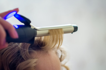 Fototapeta premium Blonde women curling hair