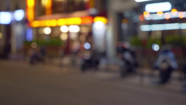 Bokeh night scene of motorcycle parked in front of shops