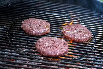 Hamburgers are cooking on the grill