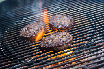 Hamburgers are cooking on the grill