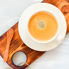 Coffee cup with a wooden spoon top view on wooden table background