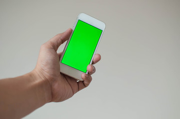 Young man holding a smart phone with green screen