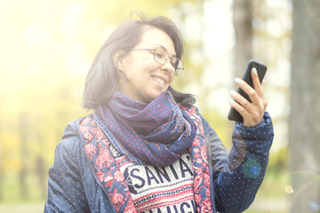 Closeup portrait of a beautiful confident woman laughing in nature. Telephone conversation with...