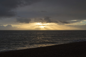 Morning sunrise with sun rays shining through clouds at Aldeburgh