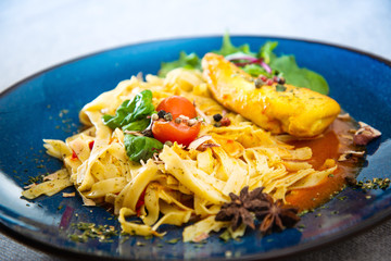 close-up of plate of pasta and chicken with lettuce